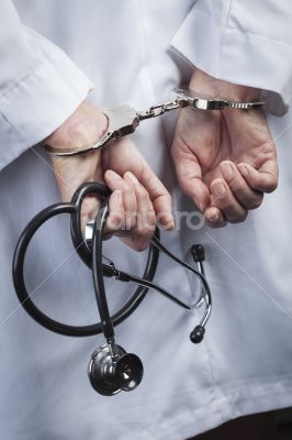 Female Doctor or Nurse In Handcuffs Holding Stethoscope