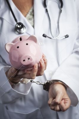 Doctor In Handcuffs Holding Piggy Bank Wearing Lab Coat, Stethos