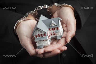Woman In Handcuffs Holding Small House