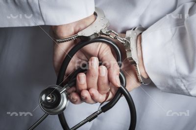 Female Doctor or Nurse In Handcuffs Holding Stethoscope