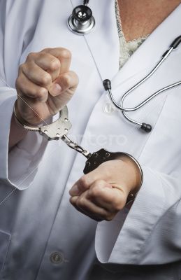 Doctor or Nurse In Handcuffs Wearing Lab Coat and Stethoscope