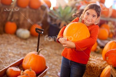 Cute Girl Choosing A Pumpkin