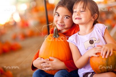 Little Girls Holding Their Pumpkins At A Pumpkin Patch