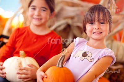 Two Cute Little Girls Holding Their Pumpkins At A Pumpkin Patch