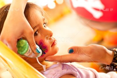 Cute Girl Gets A Face Painting At A Party