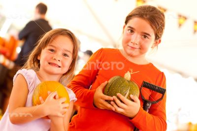 Cute Little Girls Holding Their Pumpkins At A Pumpkin Patch