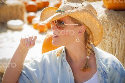 Beautiful Blond Female Rancher Wearing Cowboy Hat in Pumpkin Pat