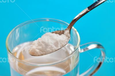 Spoon of baking soda over glass of water