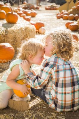 Sweet Little Boy Kisses His Baby Sister at Pumpkin Patch