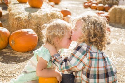 Sweet Little Boy Kisses His Baby Sister at Pumpkin Patch