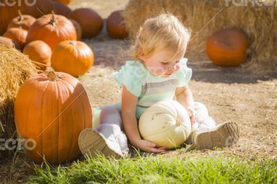 Adorable Baby Girl Holding a Pumpkin at the Pumpkin Patch