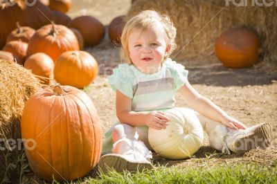 Adorable Baby Girl Holding a Pumpkin at the Pumpkin Patch