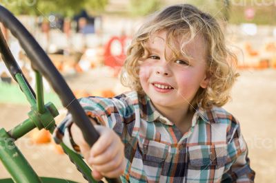 Adorable Young Boy Playing on an Old Tractor Outside