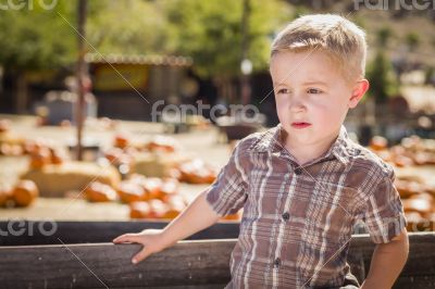 Little Boy Standing Against Old Wood Wagon at Pumpkin Patch