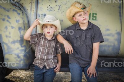 Two Young Boys Wearing Cowboy Hats Leaning Against Antique Truck