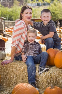 Portrait of Attractive Mother and Her Sons at Pumpkin Patch