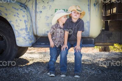 Two Young Boys Wearing Cowboy Hats Leaning Against Antique Truck