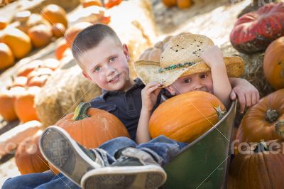 Two Little Boys Playing in Wheelbarrow at the Pumpkin Patch