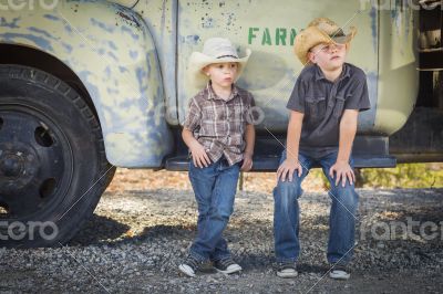 Two Young Boys Wearing Cowboy Hats Leaning Against Antique Truck