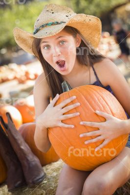 Preteen Girl Holding A Large Pumpkin at the Pumpkin Patch