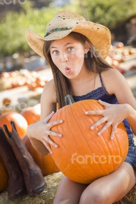 Preteen Girl Holding A Large Pumpkin at the Pumpkin Patch