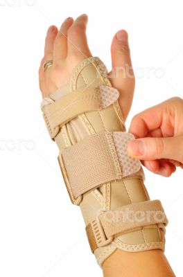 female wearing wrist brace over white background