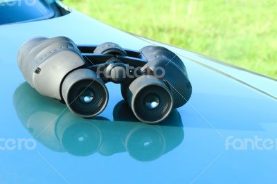 Binoculars lying on the car hood.