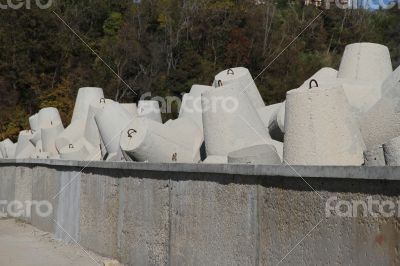 Breakwaters on the boat station. Large gray breakwaters installed at the seaport to reduce the waves.