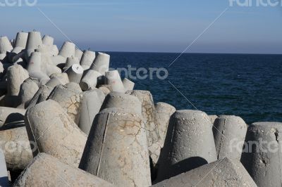 Breakwaters on the boat station. Large gray breakwaters installed at the seaport to reduce the waves.