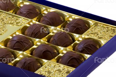 Chocolate sweets in the box on the white background.
