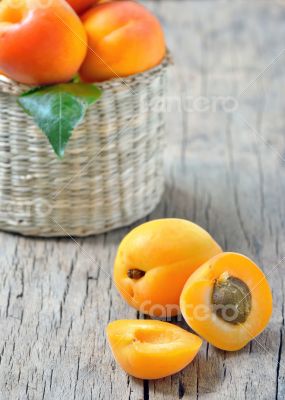 Apricots on the old wooden table and basket shoot in studio