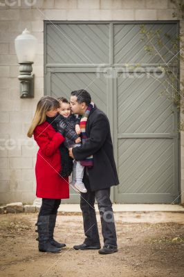 Warmly Dressed Family Loving Son in Front of Rustic Building