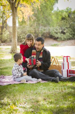 Mixed Race Family Enjoying Christmas Gifts in the Park Together