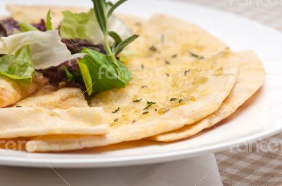 garlic pita bread pizza with salad on top