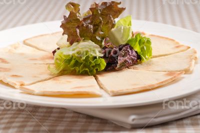 garlic pita bread pizza with salad on top