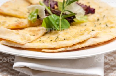 garlic pita bread pizza with salad on top