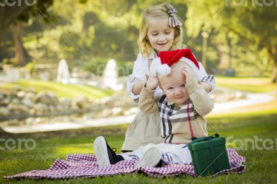 Little Girl Tries to Put Santa Hat on Baby Brother