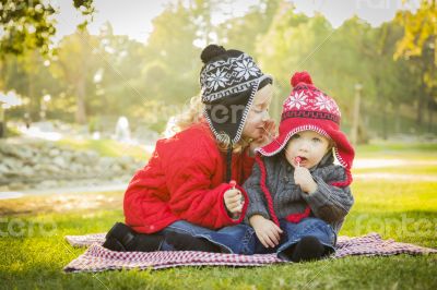 Little Girl Whispers A Secret to Baby Brother Outdoors