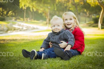 Little Girl with Baby Brother Wearing Coats at the Park