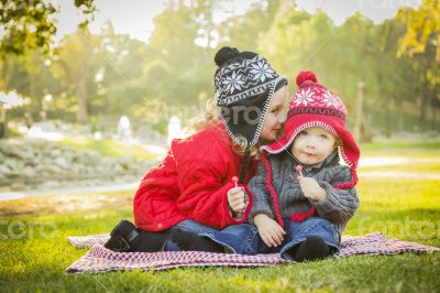 Little Girl Whispers A Secret to Baby Brother Outdoors Little Girl Whispers A Secret to Baby Brother Outdoors