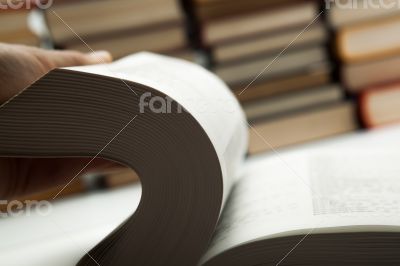 flipping book on with pile of books