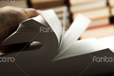 flipping book on with pile of books