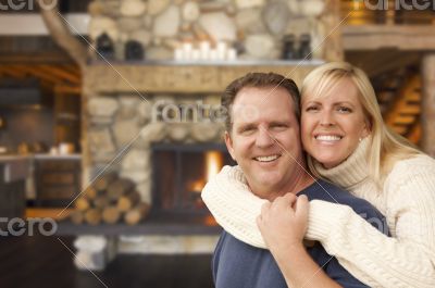 Affectionate Couple at Rustic Fireplace in Log Cabin