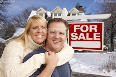 Couple in Front of New House and Real Estate Sign Couple in Front of New House and Real Estate Sign