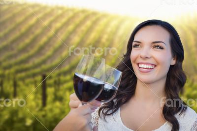 Young Woman Enjoying Glass of Wine in Vineyard With Friends