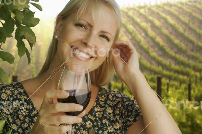 Attractive Woman Enjoying a Glass of Wine at the Vineyard