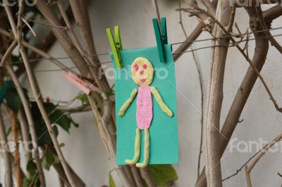 Child`s handmade small man on a green color paper 
