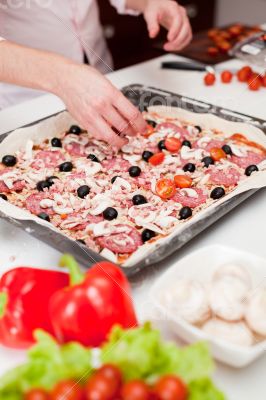 Men cooking fresh italian pizza close up