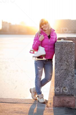 Blond woman standing with ice skates