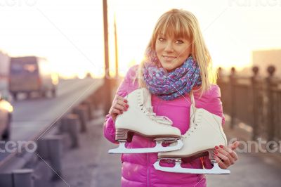 Beautiful smiling blond woman with ice skates